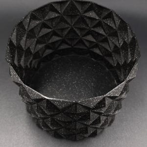 Puede incluir: Una taza de cerámica blanca con un asa negra y el texto "But First, Coffee" en negrita negra. La taza se encuentra sobre un fondo neutro, resaltando su diseño simple.