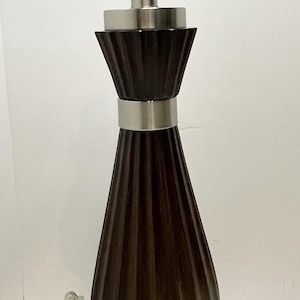 May include: A dark brown table lamp with a fluted, teardrop-shaped base and a brushed nickel finish. The lamp has a silver metal neck and base, and a standard light bulb socket. The lamp is approximately 20 inches tall.