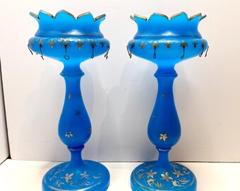 Par de candelabros victorianos de cristal opalino azul antiguo pintados a mano con detalles dorados.