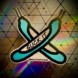 May include: A sticker featuring two crossed, stylized, turquoise-colored objects with black outlines, and the words "SUCK IT" in white. The background is a silver, geometric pattern with a rainbow holographic effect.
