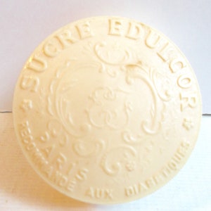 May include: A white round container with the text "SUCRE EDUCOR" and "RESERVE AUX DIABETIQUES" in a decorative font.