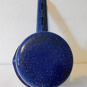 May include: Blue enamel saucepan with a speckled finish and a long handle with holes.