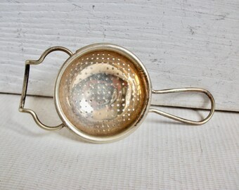 Coador de chá vintage inglês ornamentado em metal prateado com suporte para saquinhos de chá.