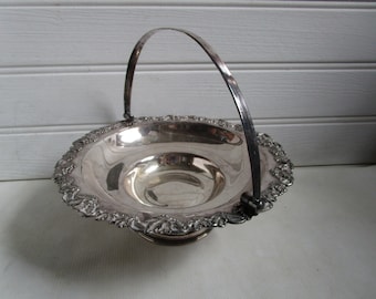 May include: A silver serving dish with a decorative rim and a handle. The dish is made of metal and has a shiny finish.