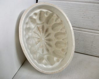 Forma de pudim antiga em faiança com motivos ornamentais tradicionais.