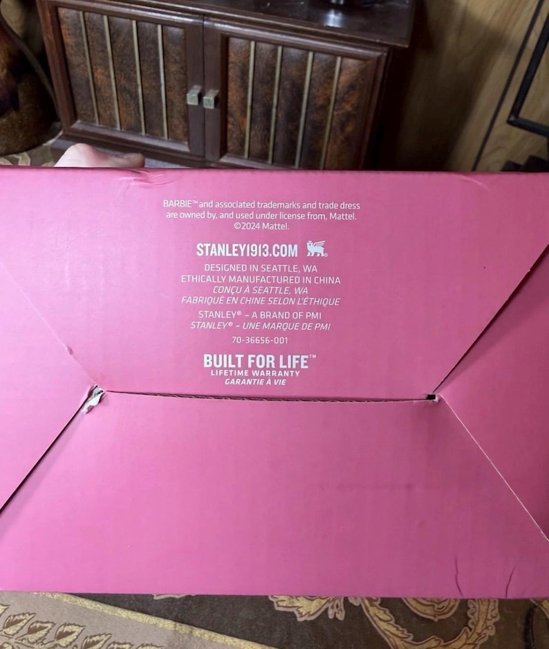 May include: A pink cardboard box with white text. The text includes "BARBIE" and "STANLEY1913.COM". The box also states "BUILT FOR LIFE" and "LIFETIME WARRANTY".