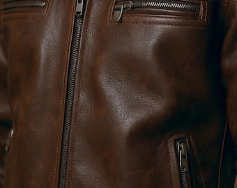 May include: A brown leather jacket with a zip fastening and several zipped pockets. The jacket features a collared neckline and a classic design. The leather has a textured finish.
