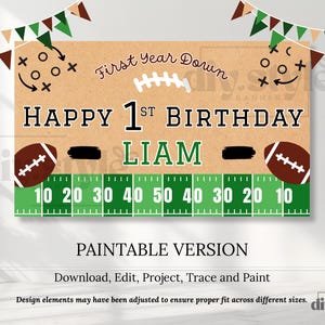May include: A football-themed birthday banner with the text "Happy 1st Birthday Liam." The banner features a football field design, footballs, and the words "First Year Down." The banner is brown, green, and white.