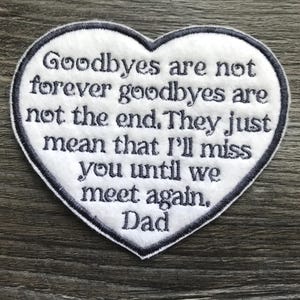 May include: A heart-shaped white fabric patch with a dark grey embroidered border and dark grey text that reads: Goodbyes are not forever goodbyes are not the end. They just mean that I'll miss you until we meet again. Dad.