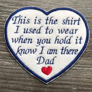May include: White heart-shaped patch with blue edging and embroidered text: "This is the shirt I used to wear when you hold it know I am there Dad". A small red heart is embroidered at the bottom.