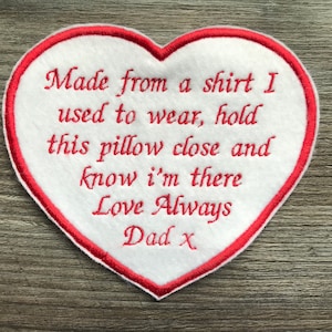 May include: White heart-shaped pillow with red embroidered edging. The pillow has an embroidered message that reads: "Made from a shirt I used to wear, hold this pillow close and know I'm there Love Always Dad x".