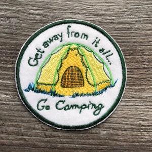 Puede incluir: Un parche bordado blanco con costuras verdes. El parche presenta una tienda de campaña amarilla con una puerta verde y el texto "Get away from it all. Go Camping".