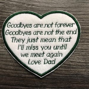 Può includere: Toppa a forma di cuore con il messaggio ricamato: "I saluti non sono per sempre, i saluti non sono la fine, Significano solo che mi mancherai finché non ci rivedremo, Love Dad." Bordo verde.