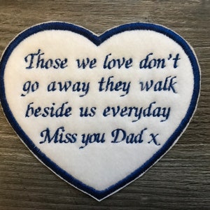 May include: White heart-shaped patch with blue embroidered edging. The patch features the text "Those we love don't go away they walk beside us everyday Miss you Dad x".