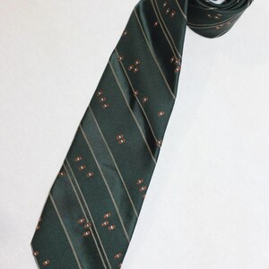 May include: A dark green tie with thin white stripes and a pattern of brown ovals.
