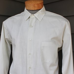 May include: A white long-sleeve button-down shirt with a single pocket on the left side.