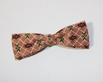 vintage 1950's -Ormond- 'clip-on' bow tie. White diamond grid on Copper w/ floating geometrics in Red & Chartruese. Super funky