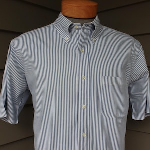 May include: A blue and white striped short-sleeved button-down shirt.