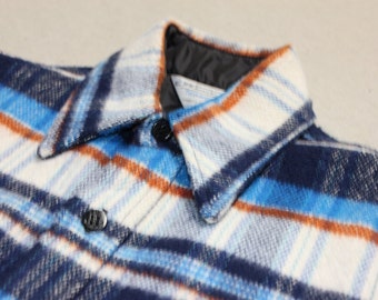 Puede incluir: Una camisa de franela a cuadros azules, blancos y naranjas con cuello abotonado.