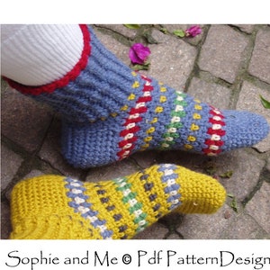 May include: A pair of crocheted socks with a colorful striped pattern. The socks are blue, yellow, red, green, and white. The socks are on a stone surface.