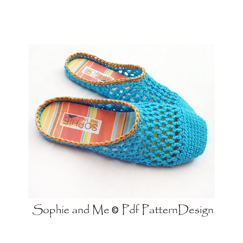 May include: A pair of blue crocheted slippers with a brown woven trim and a striped fabric insole. The insole has the text "Sophie and Me" printed on it.