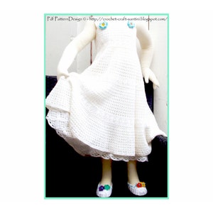 May include: White crochet dress with a scalloped hem and floral embellishments. The dress is worn by a child model and has a flowing, A-line silhouette.