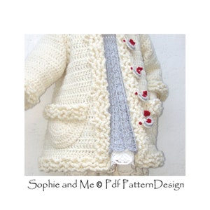 May include: A white crocheted cardigan with a scalloped edge and red buttons. The cardigan has pockets on the front and is shown being worn over a gray shirt.