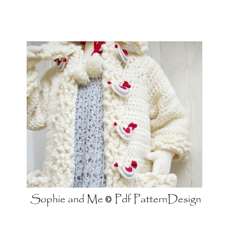 May include: A white crocheted cardigan with a hood and red and gray accents. The cardigan has a textured stitch and a pom-pom on the hood. "Sophie and Me &copy; Pdf Pattern Design" is written on the bottom of the image.