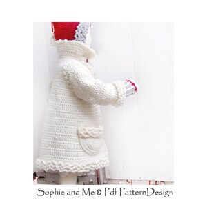 May include: A white crocheted coat with a ruffled hem and a pocket on the side. The coat is worn by a doll with a red and gray hat.