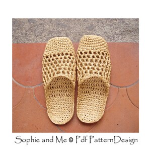 May include: A pair of beige crocheted slippers with a woven pattern. The slippers are on a tiled floor.