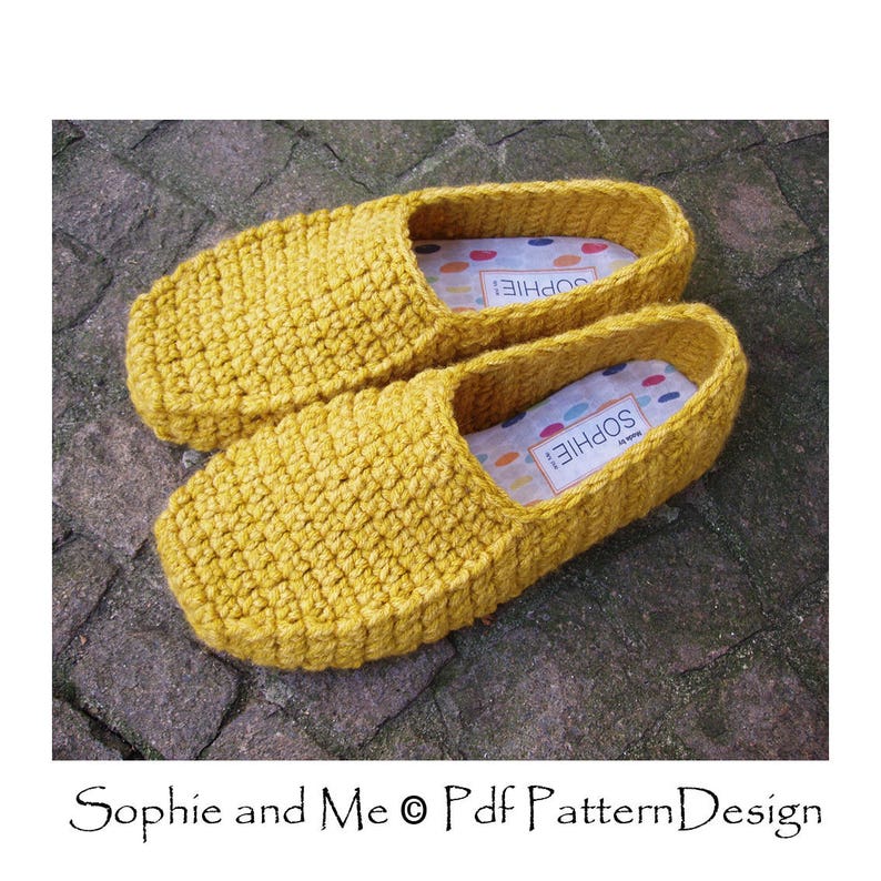 May include: A pair of yellow crocheted slippers with a white label that says "Sophie" on the inside of each slipper.