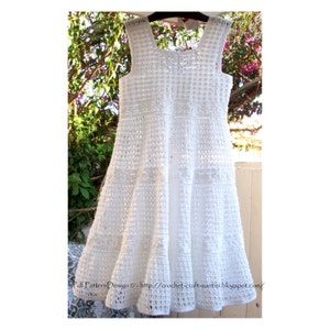 May include: White crochet dress with a sleeveless design and a flared skirt. The dress has a delicate, lacy pattern and is perfect for a special occasion.