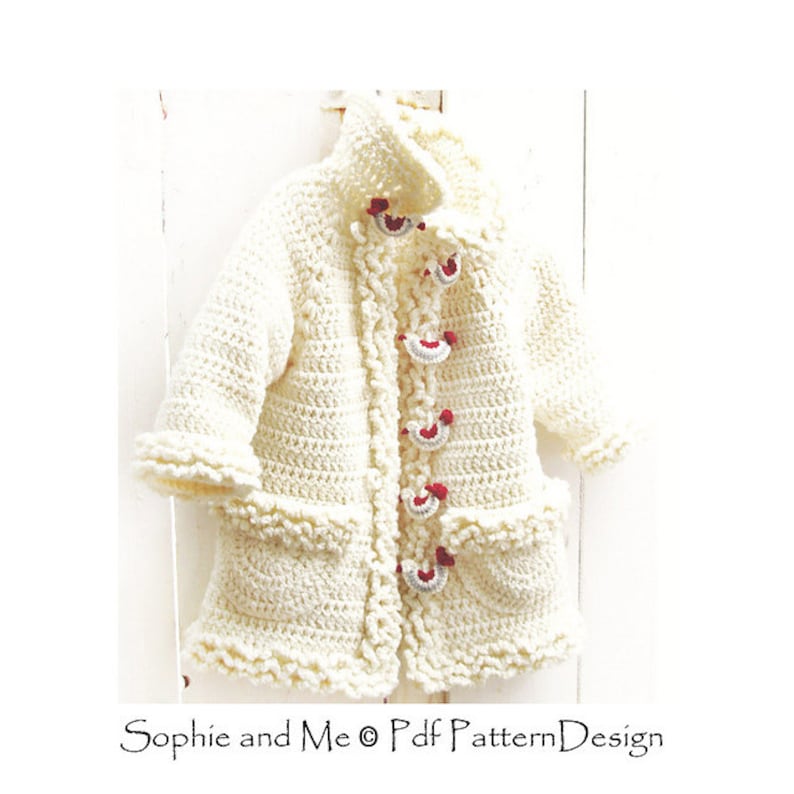 May include: A white crocheted baby jacket with red and white buttons. The jacket has a ruffled trim and pockets.