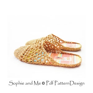 May include: A pair of beige crocheted slippers with a woven pattern. The slippers have a colorful striped insole with the text "Sophie and Me" printed on them.