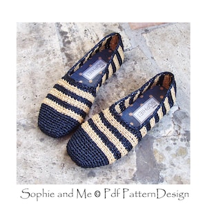 May include: A pair of black and beige striped crocheted slip-on shoes with the word "Sophie" on the insole.
