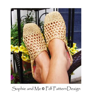 May include: A pair of crocheted beige sandals with a grid pattern. The sandals are worn by a person sitting on a wicker chair.
