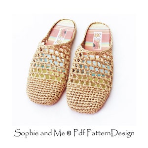 May include: A pair of beige crocheted slippers with a woven design. The slippers have a striped insole with the text "Sophie and Me" printed on them.