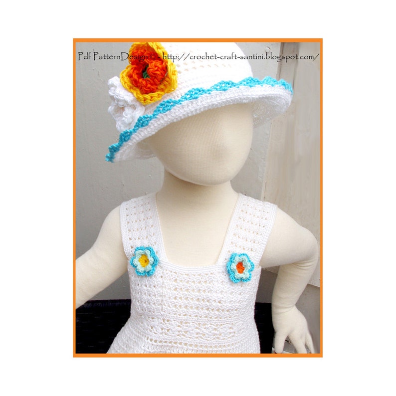 May include: White crocheted dress with blue and yellow flower accents. The dress has a sleeveless design and a square neckline. A white crocheted hat with a blue trim and a yellow and orange flower accent is also pictured.