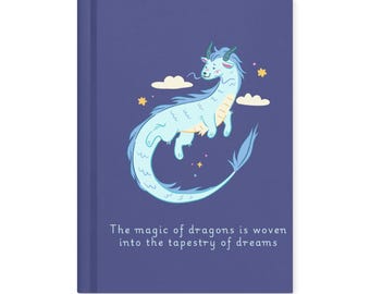 以下が含まれることがあります： 青い表紙のハードカバーノート。水色のドラゴンのイラスト、雲、星が描かれています。「The magic of dragons is woven into the tapestry of dreams」というテキストが表紙の下部に印刷されています。