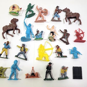 May include: A collection of vintage plastic toy figures depicting cowboys, Native Americans, and soldiers. The figures are in various colors, including green, blue, yellow, and brown. Some figures are mounted on horses or have bows and arrows.