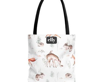 May include: White tote bag with a black handle featuring a woodland animal pattern. The design includes watercolor illustrations of deer, foxes, rabbits, and hedgehogs. The bag has the brand name "elly" on a black square.