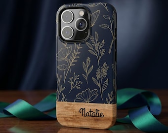 Könnte beinhalten: Eine dunkelblaue Smartphone-Hülle mit einem goldenen Linienmuster aus Blumen. Der untere Teil der Hülle besteht aus hellem Holz, in das der Name Natalie in einer schwarzen Schreibschrift mittig auf dem Holzpaneel eingraviert ist.