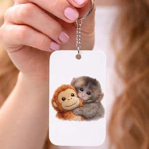 Chaveiro de pelúcia dupla face com um macaquinho fofo dando um soco e abraçando alguém | Opção de nome personalizado