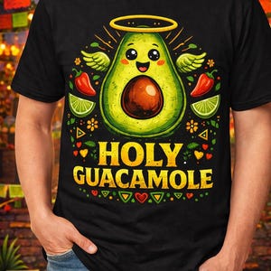 Może przedstawiać: Czarna koszulka z kreskówkowym wzorem awokado. Awokado ma aureolę i skrzydła, z napisem "HOLY GUACAMOLE" w kolorze żółtym. Czerwone papryki i plasterki limonki również w projekcie.