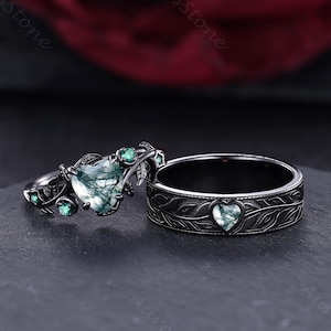 May include: Two rings, one a band and the other a set ring, both with a dark finish. The set ring features a heart-shaped green stone and smaller green stones. The band ring has a heart-shaped green stone and leaf detailing.