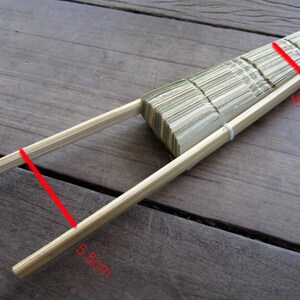 K&ouml;nnte beinhalten: Ein geschlossener, faltbarer F&auml;cher aus Holz mit nat&uuml;rlicher Oberfl&auml;che. Der F&auml;cher ist 9,5 cm lang und 5 cm breit.