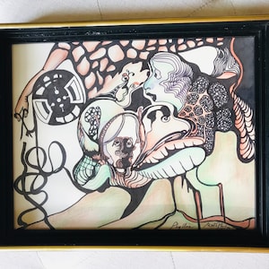 May include: A framed abstract watercolor painting with black, white, green, and orange colors. The painting features a swirling, organic design with multiple faces and a circular object. The painting is signed "Phyllis" and "Neil Burton".