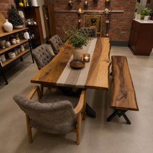 Könnte beinhalten: Ein Esstisch aus Massivholz mit Baumkante, beigem Tischläufer, Holzschale, Vase mit Grünpflanze und Kerze. Das Set umfasst drei gepolsterte, graue Stühle mit Knopfheftung und Holzrahmen sowie eine passende Holzbank mit schwarzen Metallbeinen.