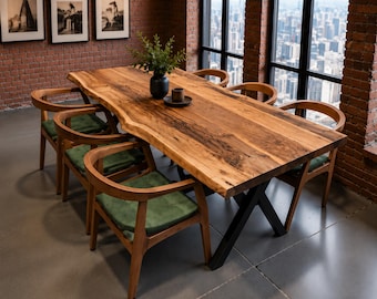 Puede incluir: Una mesa de comedor rectangular con un tablero de madera maciza de borde natural y una base de metal negro en forma de X, acompañada de seis sillas de madera con respaldos curvos y cojines verdes, con un jarrón y un cuenco encima.