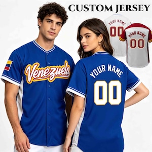 Könnte beinhalten: Ein blaues Baseballtrikot mit dem Wort Venezuela in gelber und roter Schreibschrift auf der Vorderseite, einer kleinen venezolanischen Flagge am Ärmel und dem Text Your Name mit der Nummer 00 in Weiß und Gelb auf der Rückseite, mit Knopfleiste.